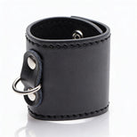 Black leather-style 2-inch ball stretcher cuff with silver D-ring attachment and smooth stitched finish