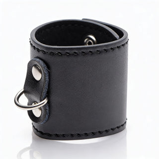 Black leather-style 2-inch ball stretcher cuff with silver D-ring attachment and smooth stitched finish