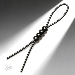 4-Way Adjustable Cock and Ball Tie with black cord and sliding beads, flexible design for adjustable tension and secure fit