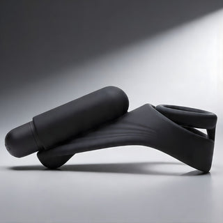 Side view of black silicone c-ring with curved arm and attached bullet vibrator designed for targeted stimulation