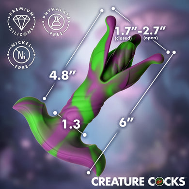 A 3D render of a novelty cock-shaped product with green and purple coloration, overlaid with dimension lines and text showing measurements for closed and open states, plus badges reading premium silicone, phthalate free, and nickel free. 