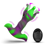 A green and purple silicone clitoral stimulator with a curved base, shown alongside a black wireless remote control on a clean white background. The graphic includes pink arrows and wavy lines indicating motion and sensation.