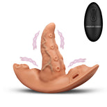 A silicone anal butt plug shown on a white background, featuring a peach-colored curved base with a central textured protruding shaft, pink wavy graphic lines around it, and a black oval remote control labeled 'CREATURE COCKS' in the upper right.