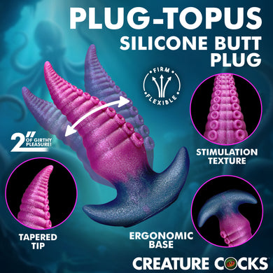 Promotional graphic for the Plug-Topus Silicone Butt Plug by Creature Cocks, showing a 2-inch tapered butt plug with a pink-to-purple gradient and suction-stripe texture. The graphic includes circular insets highlighting the tapered tip, stimulation texture, and ergonomic base, set against a dark teal background with text detailing product features.
