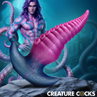 A fantasy creature figurine or print showing a muscular male figure with purple hair and blue skin patterns, surrounded by pink tentacles and a large pink-and-blue curved tail-like structure, set on a rock with the text 'CREATURE COCKS' at the bottom.