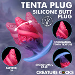 A promotional graphic for a silicone butt plug labeled 'TENTA PLUG' with the text 'Silicone Butt Plug.' The main product is shown as a pink and blue curved plug with suction-cup texture, plus three circular inset close-ups and callout labels including 'Firm & Flexible,' 'Stimulation Tenta Texture,' 'Tapered Tip,' 'Ergonomic Base,' and 'Creature Cocks.