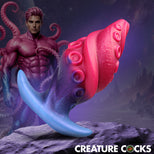 A novelty fantasy figurine or collectible featuring a pink and blue octopus-like creature in the foreground, with a muscular purple humanoid figure in the background, set against a dark cosmic landscape. The text 'CREATURE COCKS' appears at the bottom right.