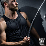 Apex Shower Set in use, bearded model in a soaked black tank top gripping the silicone nozzle as water sprays