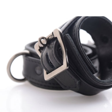 Close-up view of the adjustable metal buckle and reinforced construction on a black locking ankle restraint cuff