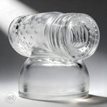 Clear textured sleeve attachment with internal ridges and flexible opening, designed to fit over wand massager heads for enhanced sensation