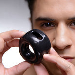 The Cock Holster Cock and Ball Ring in black shown in hand, smooth ergonomic design with dual openings for penis and testicles