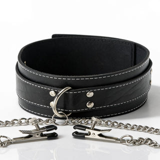 Close-up of a black bondage collar featuring decorative stitching, metal O-ring, chain attachment, and adjustable nipple clamps