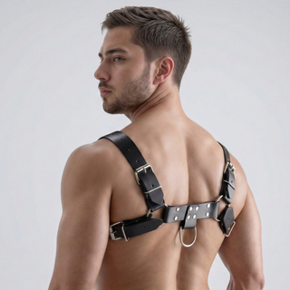 Rear view of a male model wearing a black faux leather English Bulldog harness with adjustable shoulder and chest straps and rear D-ring attachment point