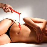 Red fetish drip candle with warm wax dripping onto skin during temperature play scene for heightened sensation