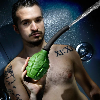 Grenade anal douche bulb spraying water, held by a model in the shower, Fort Troff