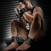 Leather Ankle Cuffs and wrist cuffs chained together on a seated model in a harness, Fort Troff
