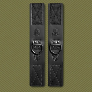 Leather Ankle Cuffs bondage restraints pair laid flat, black leather with steel D-rings and velcro, Fort Troff