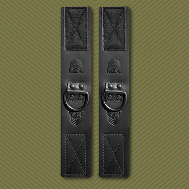 Leather Ankle Cuffs bondage restraints pair laid flat, black leather with steel D-rings and velcro, Fort Troff