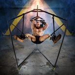 Harnessed model with arms overhead in the Hammock Hangar Velvet Guard sex sling, legs spread in the stirrups