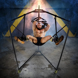 Harnessed model with arms overhead in the Hammock Hangar Velvet Guard sex sling, legs spread in the stirrups