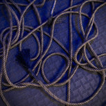 Grunt Rope bondage rope loosely looped on the floor with frayed tassel end