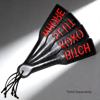 Set of black imprint spanking paddles with red lettering including OXOX, SLUT, WHORE, and BITCH designs, sold separately