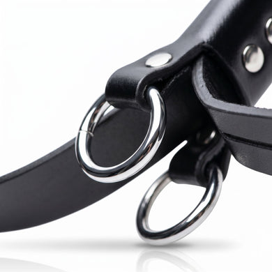 Close-up of reinforced metal attachment rings mounted on black bondage cuff straps