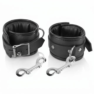 Padded black bondage wrist cuffs with quick-release clips displayed on a white background
