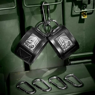 Neo Ankle Restraints pair with steel D-rings and carabiners on an ammo can