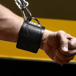 Neo Wrist Restraint on a clenched fist, black neoprene with steel D-ring