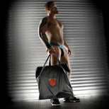 Rimmer Bag ballistic nylon carry bag held by a model in a jockstrap, Fort Troff logo on the side