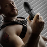 Robo Rimmer Slim plug held up by a bearded model in a chain harness