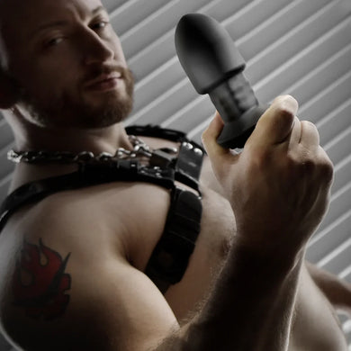 Robo Rimmer Slim plug held up by a bearded model in a chain harness