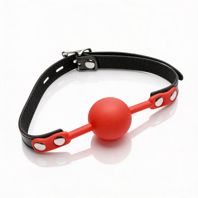Black adjustable faux leather ball gag with bright red silicone comfort ball and silver buckle hardware on white background