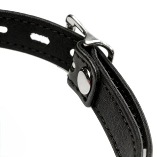 Close-up of adjustable silver buckle hardware and stitched black faux leather strap on silicone ball gag