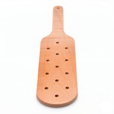 Front view of a perforated wooden impact paddle featuring a rounded striking head and smooth handle