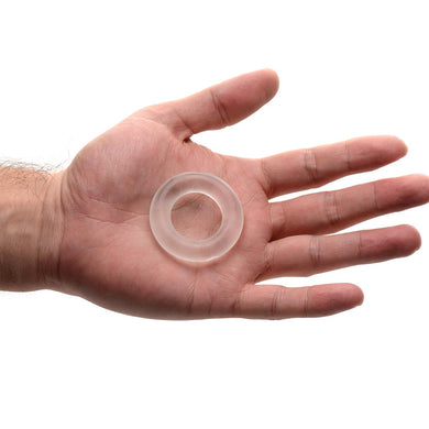 Super Stretch Universal Cock Ring resting in an open palm to illustrate its compact size, clear material, and smooth rounded profile